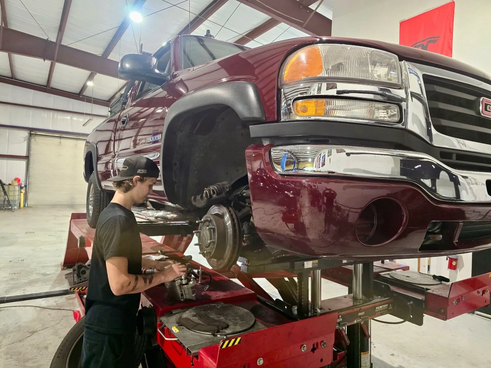 Technician rebuilding the front brakes on a GMC Sierra 2500HD at 239 Mechanics