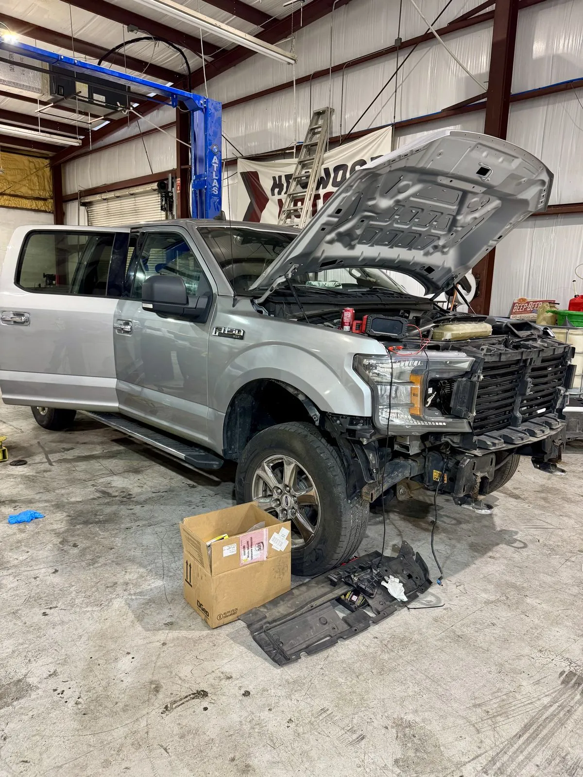 Ford F-150 with the hood open and front bumper removed for engine work at 239 Mechanics