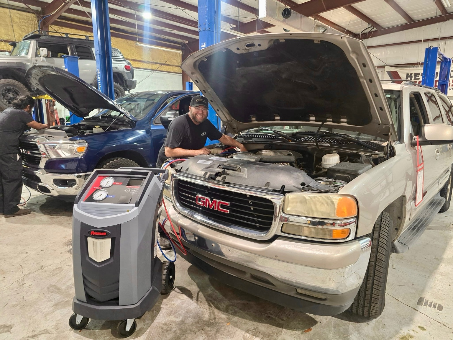 239 Mechanics technician performing AC service on a GMC truck