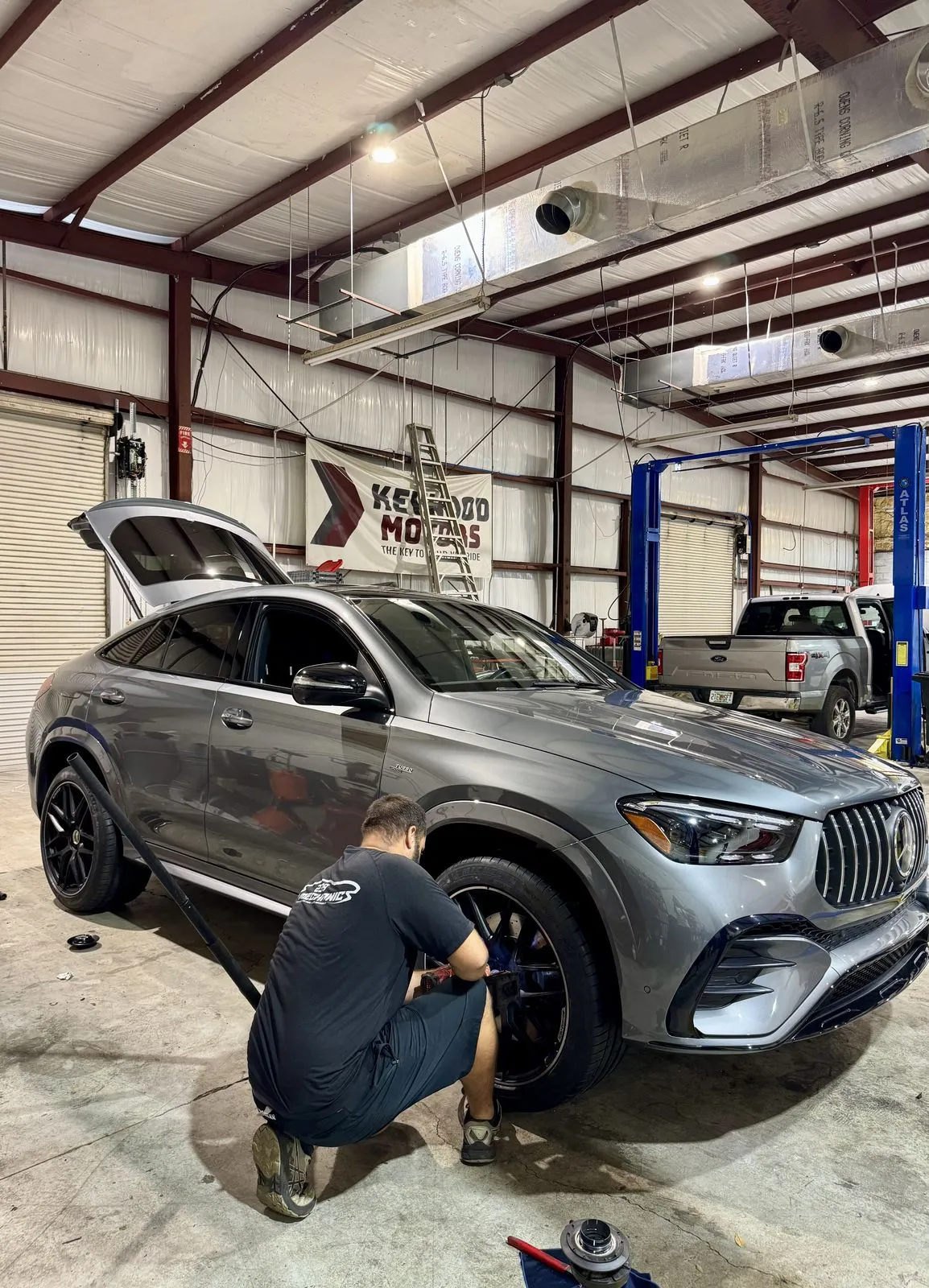 Technician servicing the front wheel of a Mercedes-Benz GLE at 239 Mechanics in Cape Coral